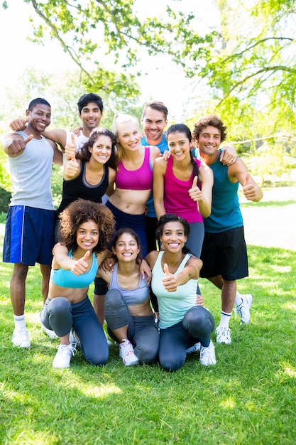 Friends in sportswear showing thumbs up