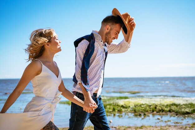 Foto amici in piedi sulla spiaggia contro il cielo