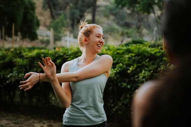 Photo friends stretching together in the park