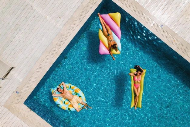 Amici in costume da bagno in piscina che si abbronzano