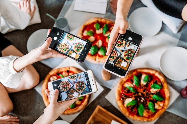 レストランで食べ物の写真を撮っている友達