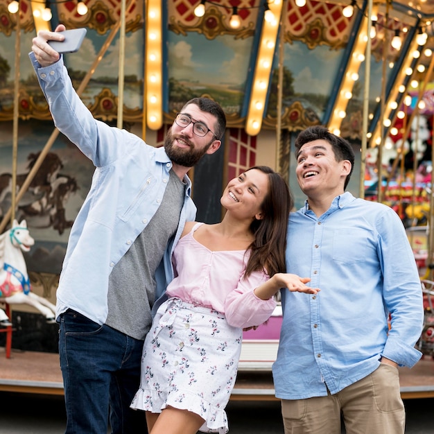 Foto amici che prendono selfie al parco di divertimenti