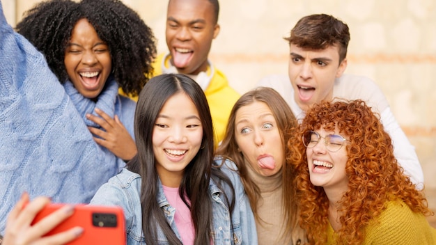 Foto amici che si fanno un selfie all'aperto facendo facce divertenti.