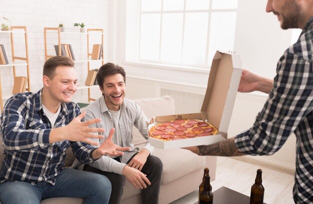 Photo friends taking slices of hot pizza from delivery box
