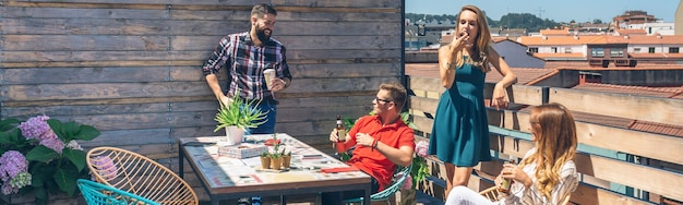 Foto amici che parlano e bevono a una festa su una terrazza