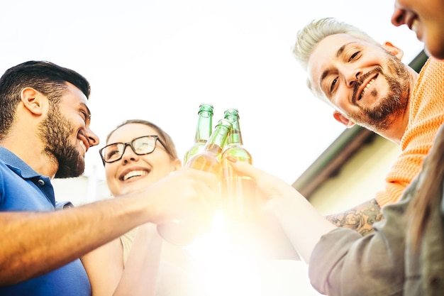 Foto amici che brindano a bottiglie di birra all'aperto