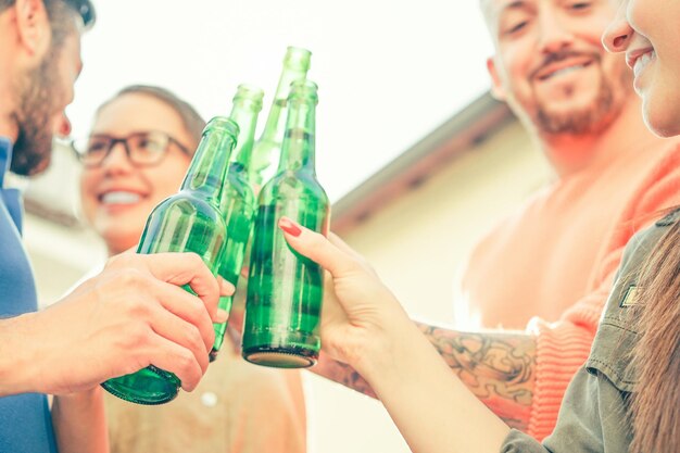 Foto amici che brindano a bottiglie di birra all'aperto