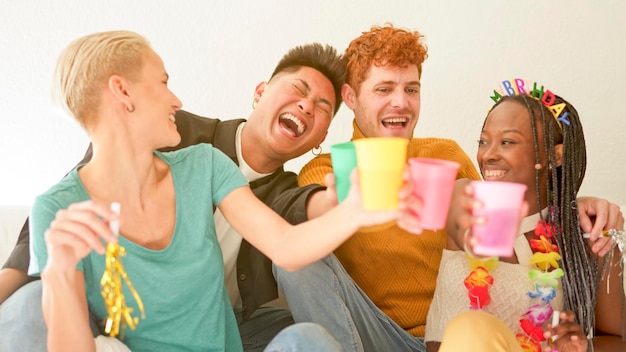 Friends toasting and laughing while celebrate at home