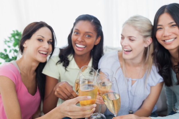 Friends toasting with white wine and smiling 