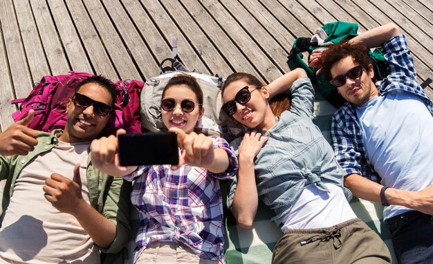friends or tourists with backpacks taking selfie