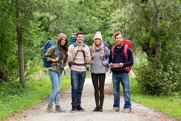 friends or travelers hiking with backpacks and map