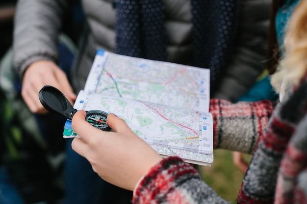 Photo friends travelers holding map and compass