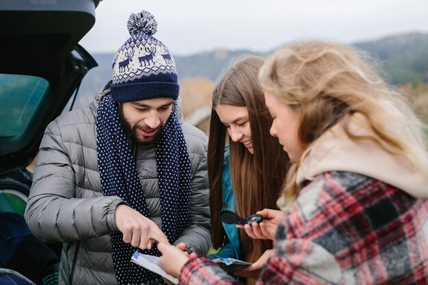 Friends use map and compass outdoors