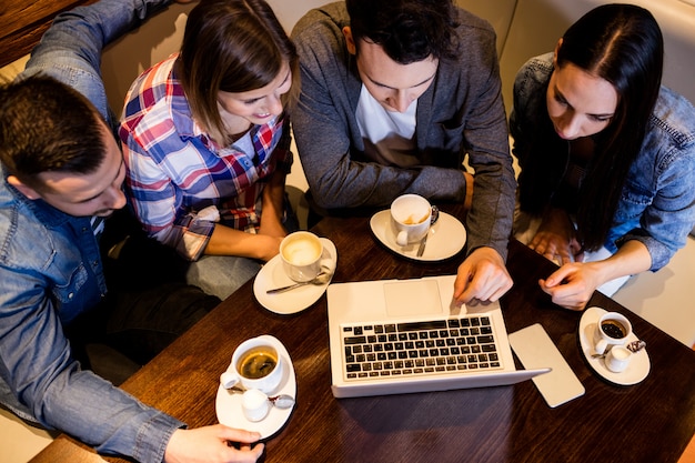 Friends using laptop at restaurant