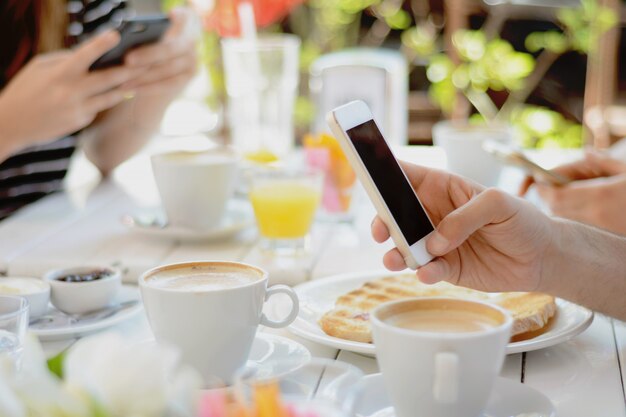 Amici che utilizzano smartphone una caffetteria.