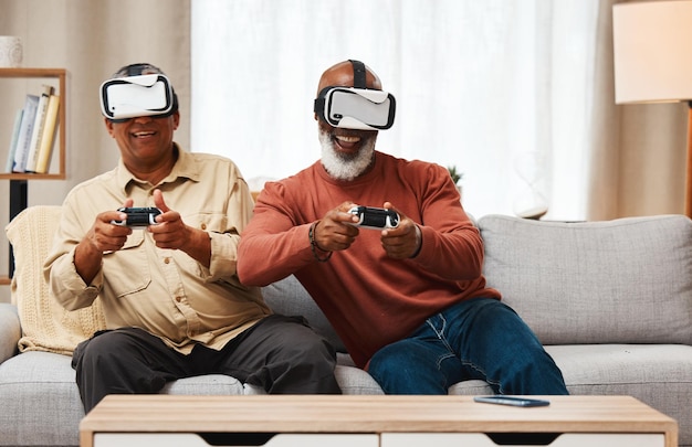 Friends virtual reality and senior men gaming in home on sofa in living room while laughing 3d vr metaverse gamer and smile of happy retired people playing fun futuristic games with controller