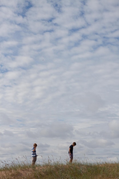 사진 친구들은 구름이 가득한 하늘을 향해 들판을 고 있습니다.