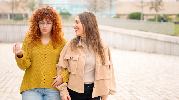 Friends walking relaxed together and talking along the street