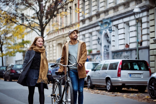 friends walking with cycle on street during winter