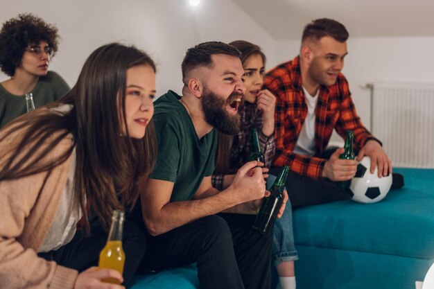 Friends watching football game at home and cheering