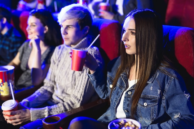 映画館で映画を見ている友人