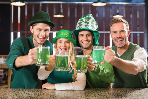 Friends wearing St. Patricks day associated clothes toasting