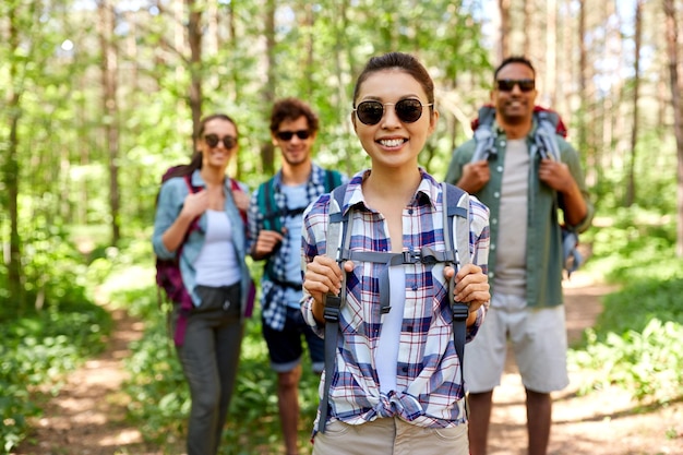 Photo friends with backpacks on hike in forest