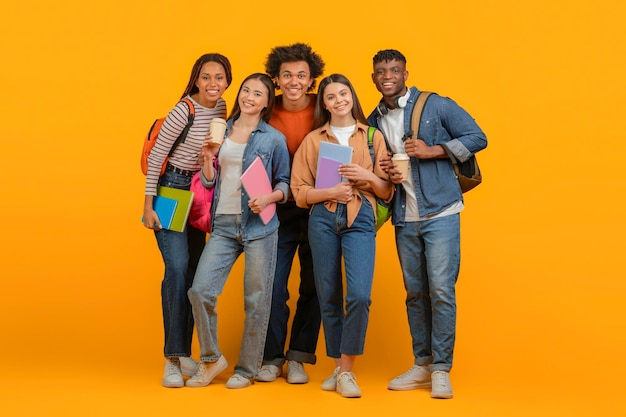 Friends with backpacks ready for school on orange background