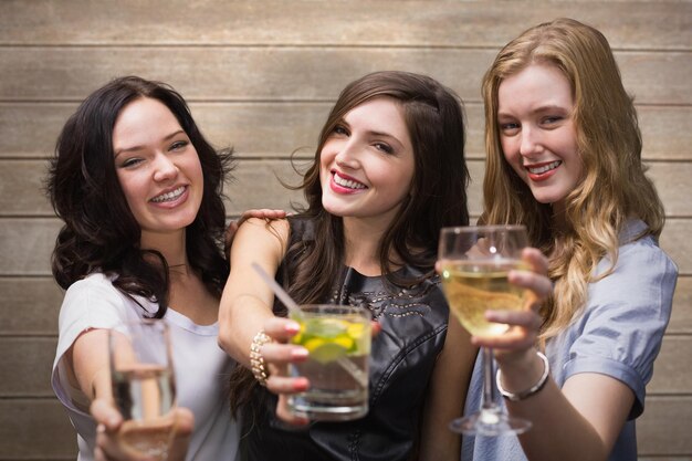 Photo friends with drinks against wooden surface with planks