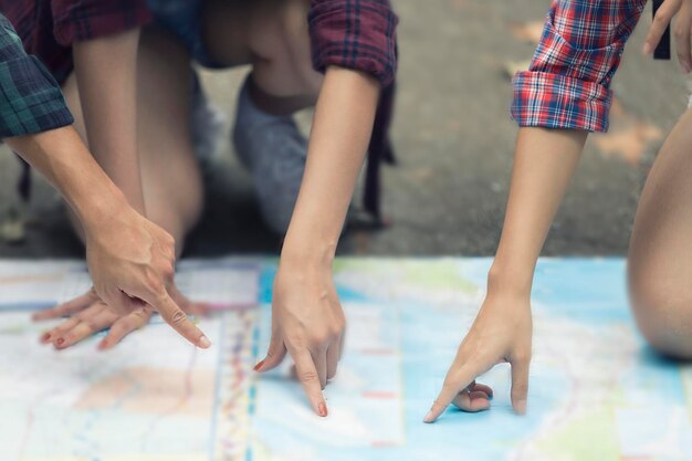 Foto amici con le mani sulla mappa