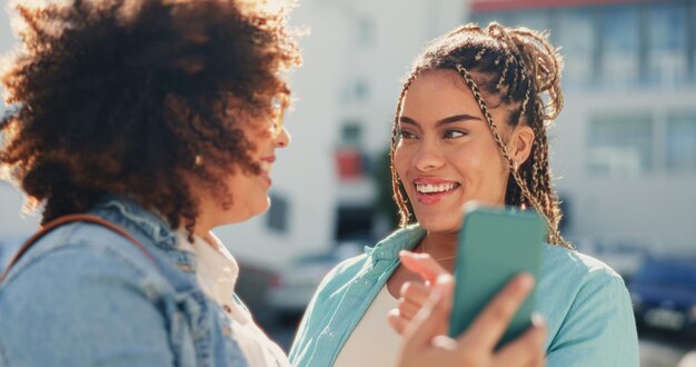 Foto amici donne che ridono e telefonano in città per messaggi divertenti sui social media o umorismo online cellulare con tecnologia 5g e sorriso di ragazze felici con cellulare per commedie comiche o scherzi su internet