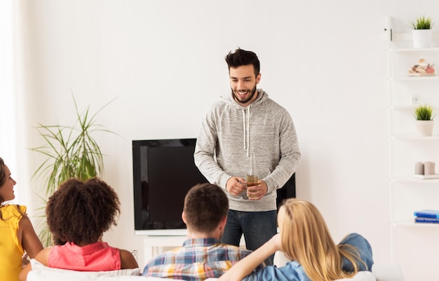 friendship, communication and people concept - group of happy friends talking at home