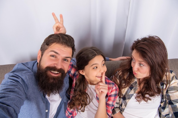 Friendship father mother and child on sofa friendly family having fun