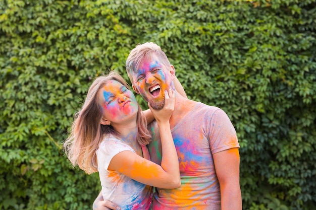 Friendship, festival of holi, people concept - young couple playing with colors at the festival of holi.