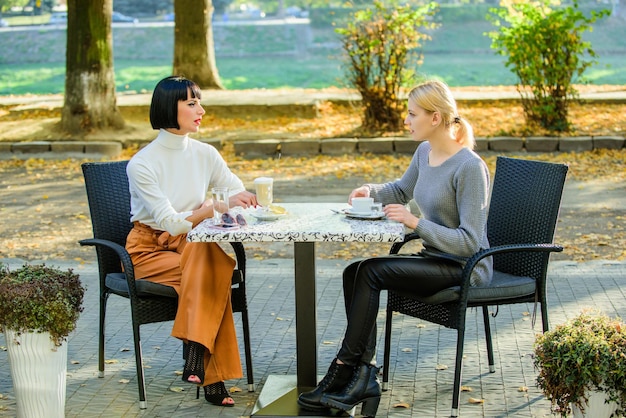 Relazioni amichevoli di amicizia discutere di voci comunicazione fiduciosa sorelle dell'amicizia incontro di amicizia tempo libero femminile le amiche bevono caffè parlano conversazione donne terrazza del caffè