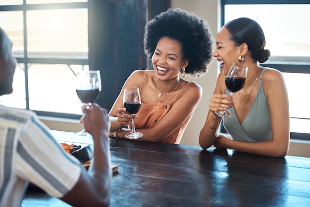 Дружеское веселье и праздник со счастливой группой, сближающейся и пьющей вино вместе в ресторане Разнообразные друзья смеются, напиваются и беззаботно празднуют хорошие новости и свободу