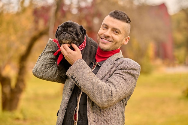 Friendship. A happy smiling man with his dog in the park