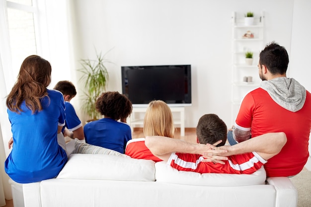 friendship, leisure, sport, people and entertainment concept - happy friends or football fans watching soccer on tv at home