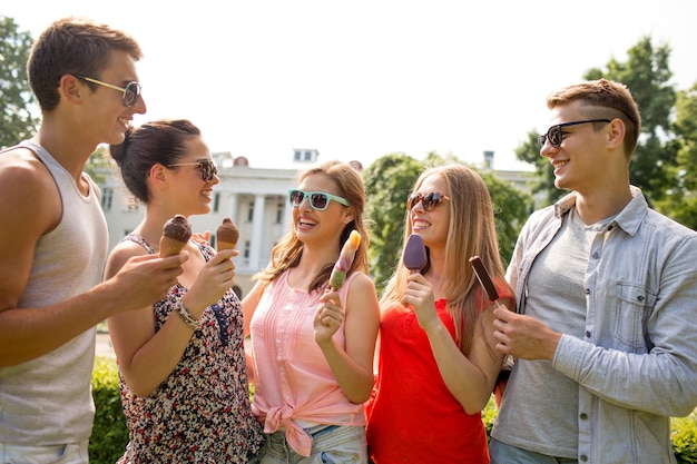 Foto concetto di amicizia, tempo libero, dolci, estate e persone - gruppo di amici sorridenti con gelato all'aperto