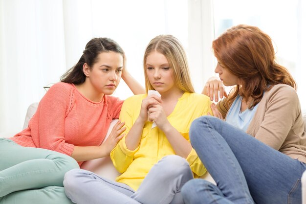 Friendship and people concept - two teenage girls comforting another after break up