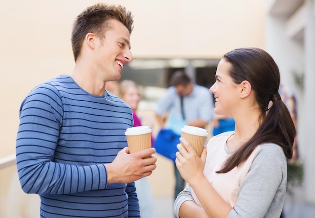 友情、人、飲み物、教育の概念-屋外で紙のコーヒーカップを持って笑顔の学生のグループ