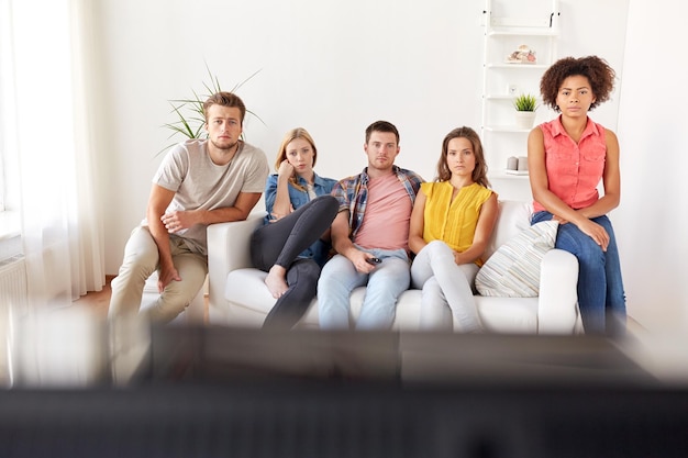 우정, 사람들, 대중 매체 및 텔레비전 개념 - 집에서 TV를 보는 슬픈 친구