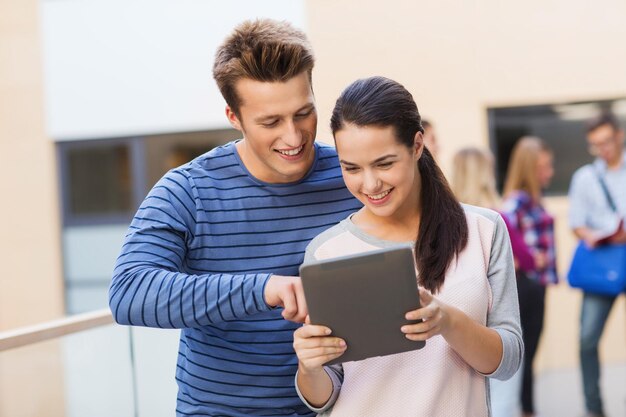 friendship, people, technology and education concept - group of smiling students with tablet pc computer outdoors