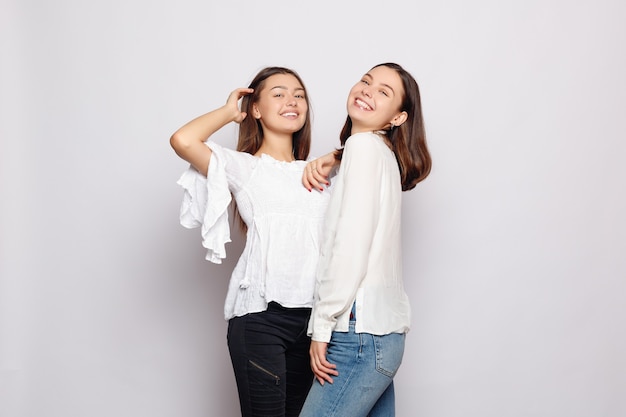 Friendship, t-shirt designe and happy people concept.  two laughing girls in white blank t-shirts