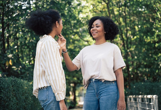 Friendship two young beautiful smiling girls and fun talking in the garden