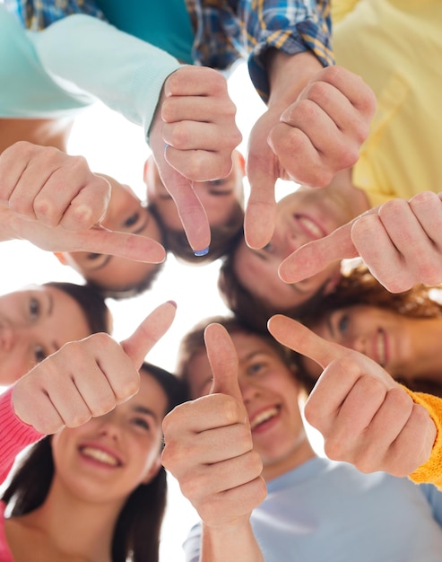 Foto amicizia, gioventù, gesto e persone - gruppo di adolescenti sorridenti in cerchio che mostra i pollici in su