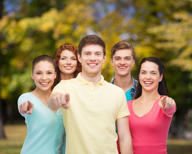 friendship, youth and people concept - group of smiling teenagers pointing fingers on you