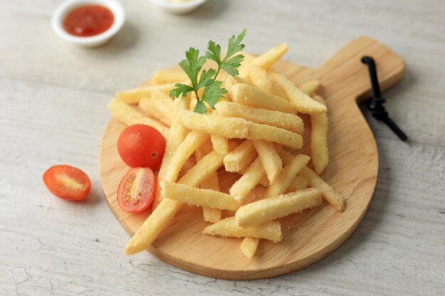 Fries geserveerd op een houten plank bedekt met specerijen en zout