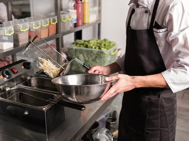 Frieten - beste junkfood ooit. Kok bereiden van fast food in de keuken van het restaurant.