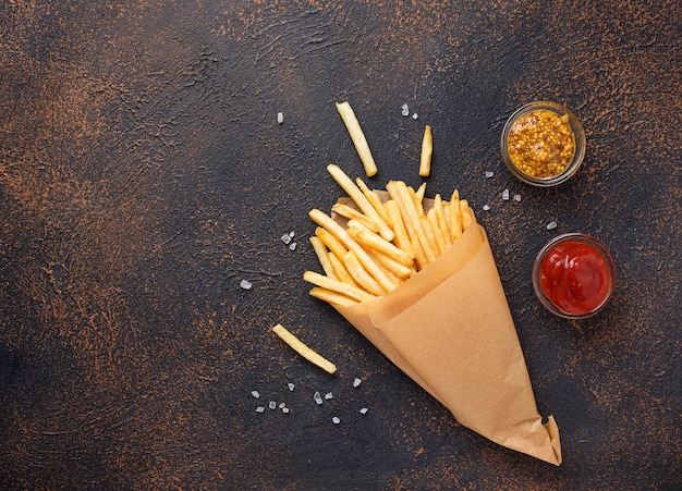 Frieten in een papieren zak met sauzen